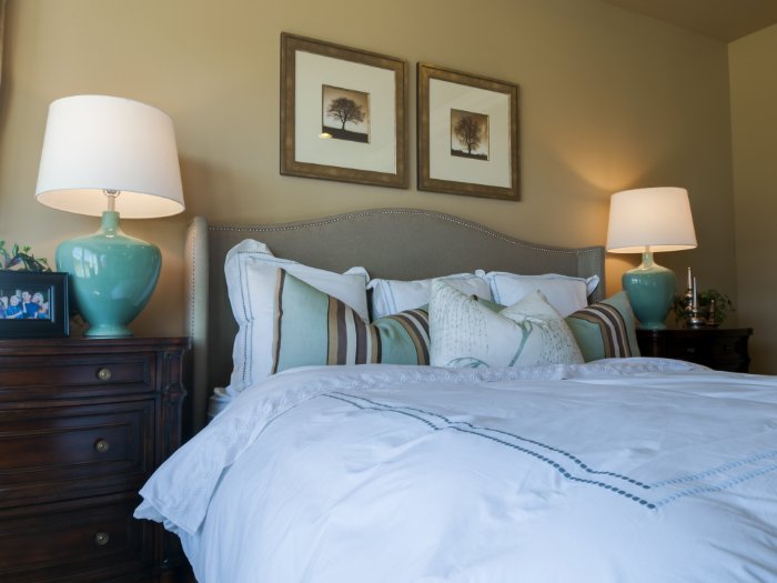 Um quarto elegante com duas fotos bem emolduradas acima da cama
