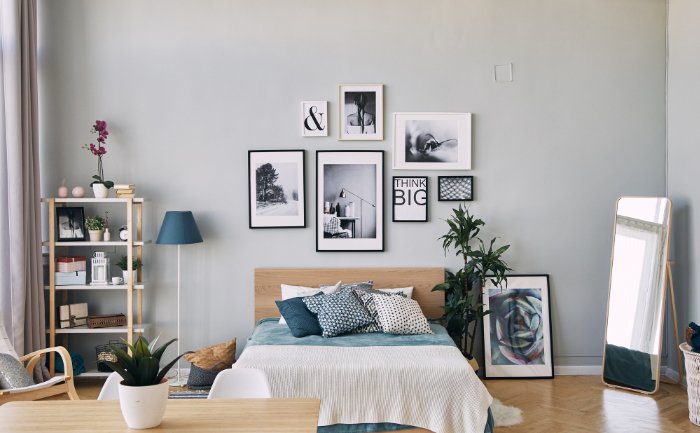 Um quarto moderno com várias fotos emolduradas acima da cama.