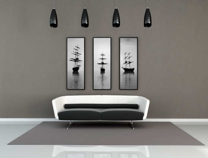 Uma foto de arte de um sofá elegante com três fotos emolduradas na parede atrás dele