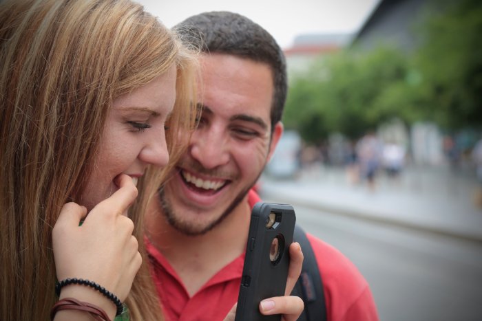 Young couple checking how they look in their phone before a photo