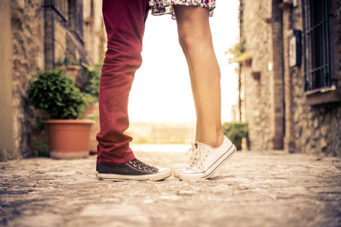 Picture of a couple standing face to face, but only their legs and feet are visible