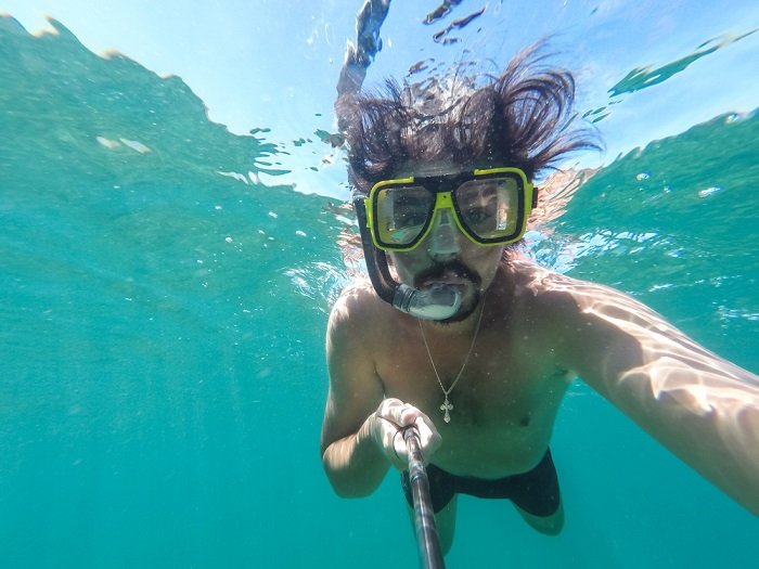 Snorkeler underwater using an action camera