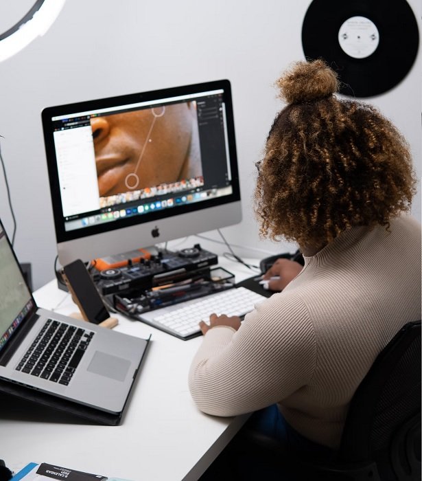 Woman editing photos on a computer and laptop