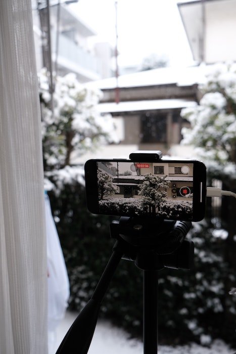 phone on tripod taking video of the snow