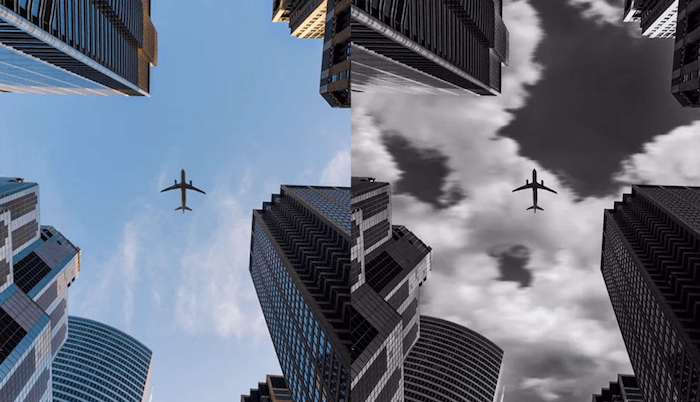 a plane flying between buildings 