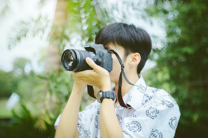 Young man holding a camera to his face