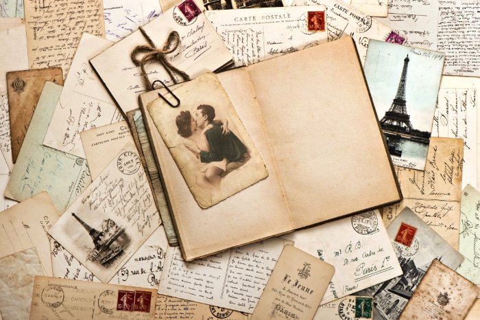 A picture of an old journal surrounded by postcards