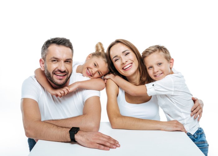 A young family dressed in white against a white background