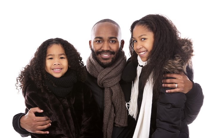 Father with daughters in black winter jackets on white isolated background