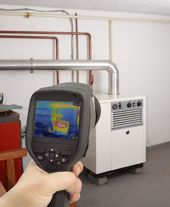 An engineer taking a thermal image of a HVAC unit