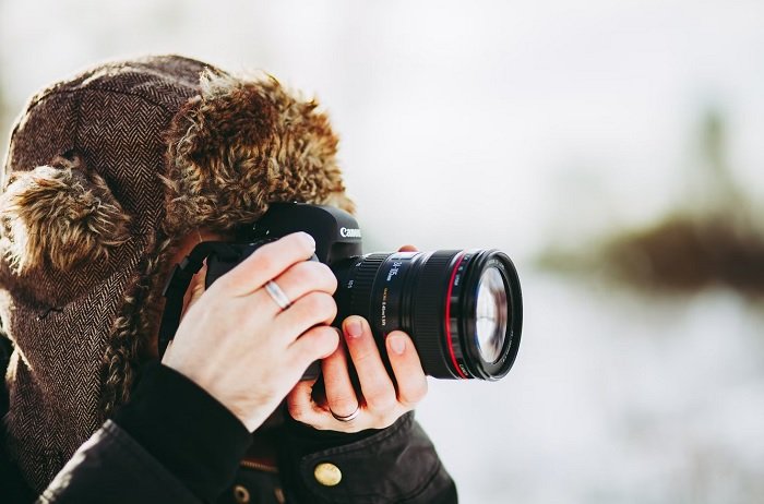 Man in wooly hat using a full frame Canon camera