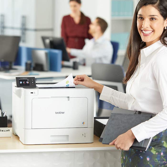 Business woman using a color laser printer in an office