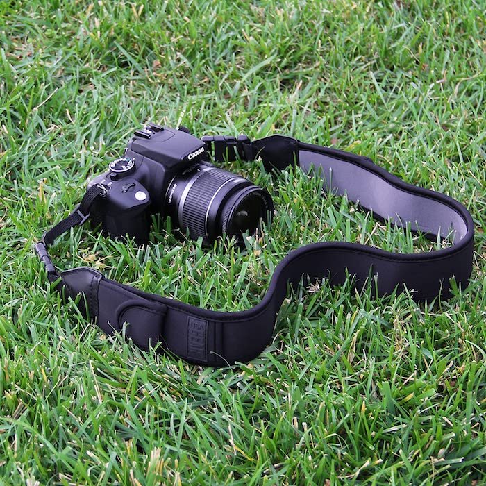 TrueSHOT camera strap and Canon DSLR camera in grass