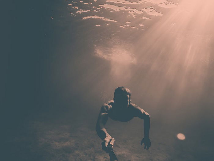 Diver taking a selfie while swimming underwater using a GoPro action camera