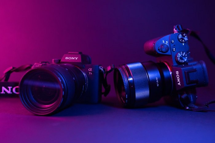 Two Sony cameras in pink and purple lighting