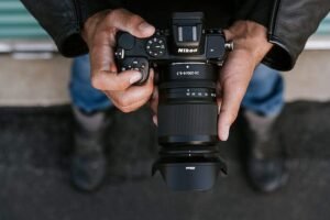 A person holding a Nikon Z lens on a mirrorless camera