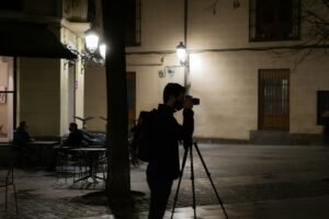A photographer shooting at night with the best camera tripod
