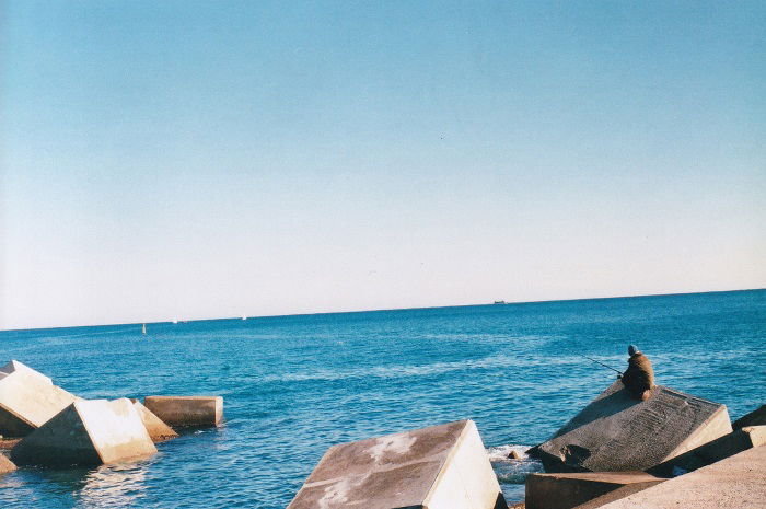 Fisherman fishing on a concrete pier in Barcelona