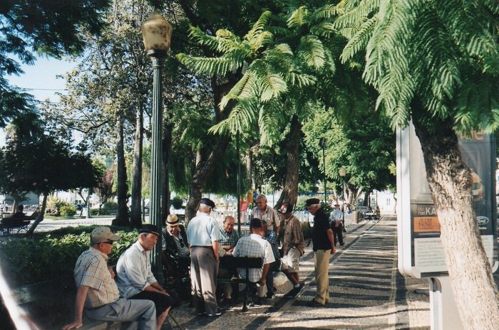 Old men gathered together in the street in Portugal