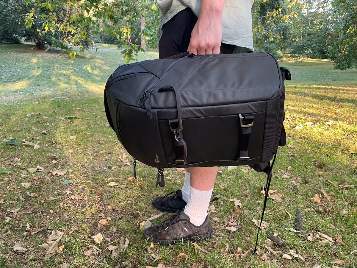 A person holding the Lowepro Freeline with the side handle