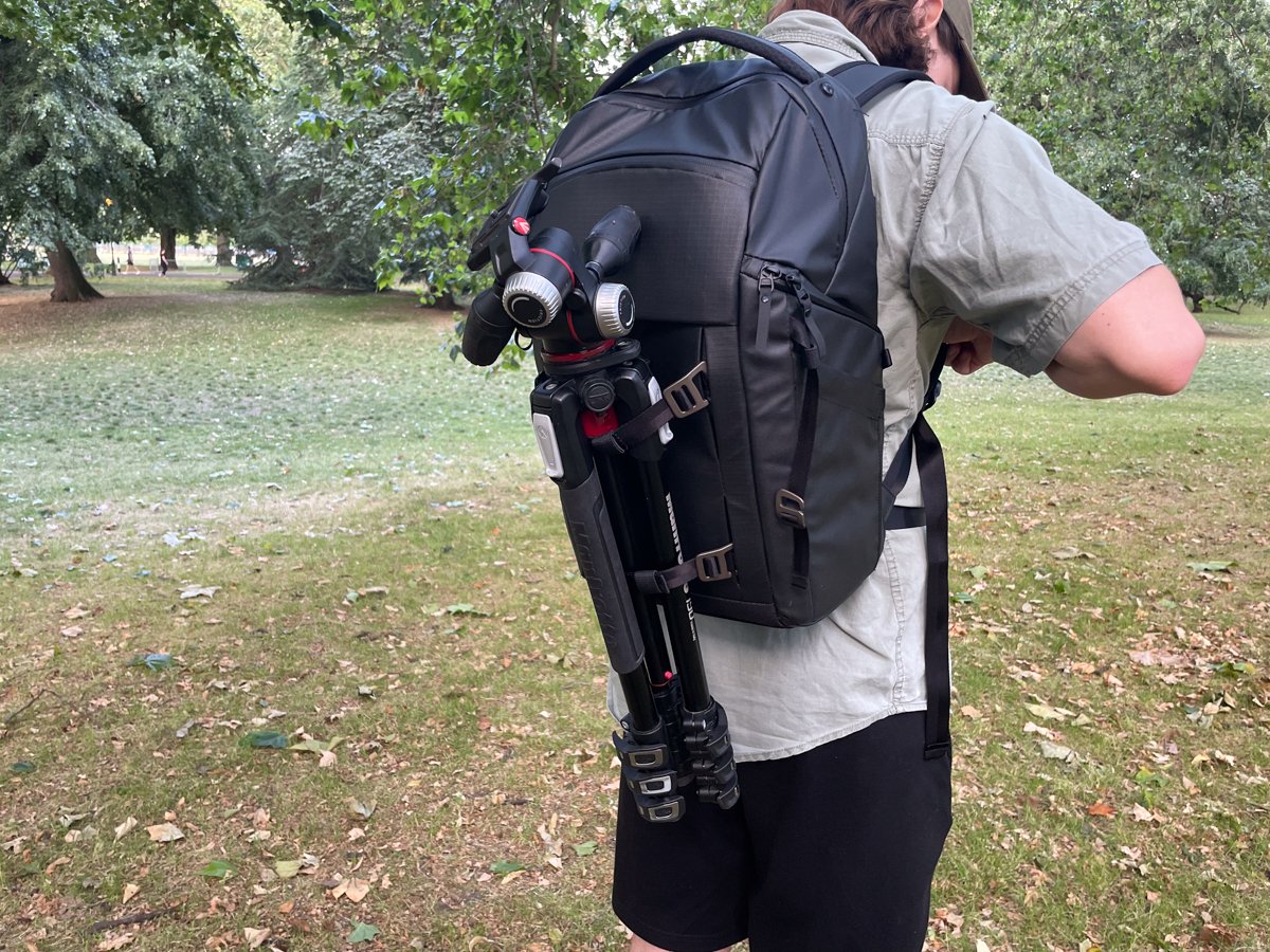 A person wearing the Lowepro Freeline with tripod attached on the back