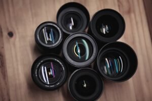 Seven camera lenses on a wooden table