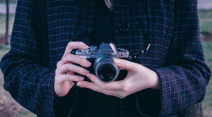 Female hands holding an Olympus Micro Four Thirds Camera