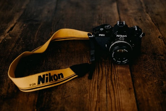 Nikon FM2 with yellow strap on a wooden table