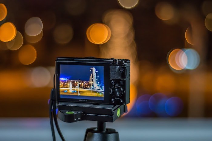 point and shoot camera on a tripod taking picture of city at night