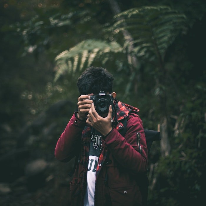 man shooting with dslr in forest