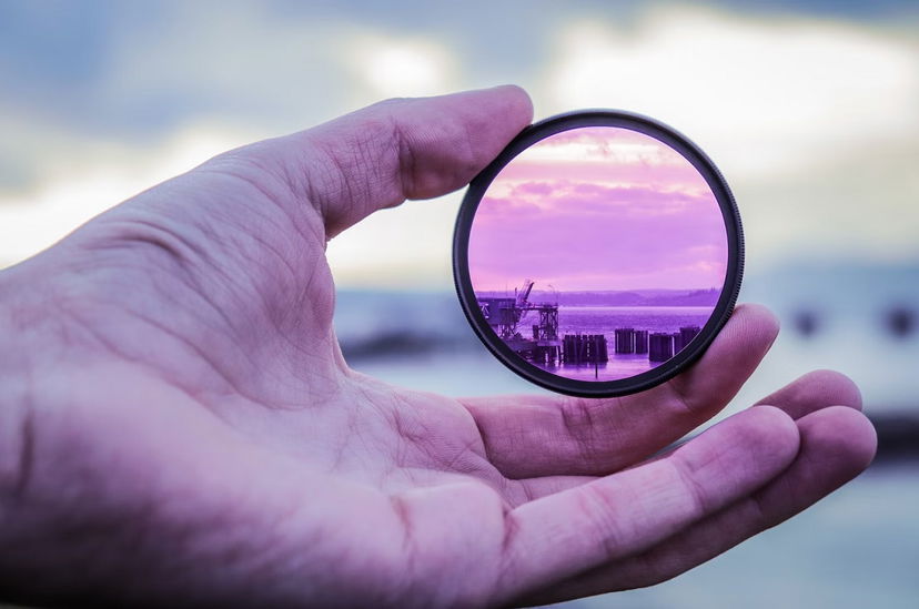 Human hand holding a purple camera filter