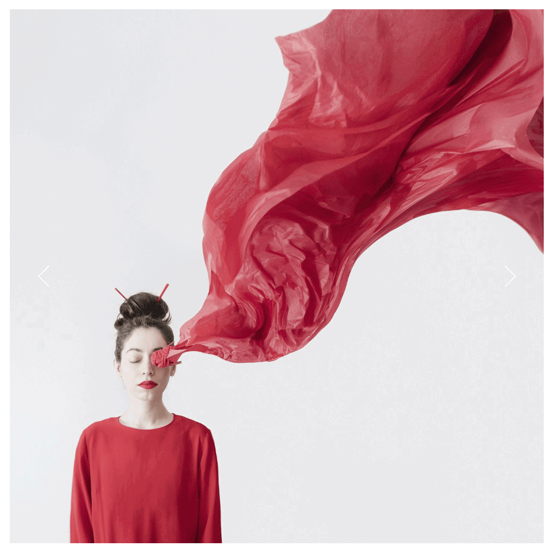 Woma's portrait with red sheet flying up from face