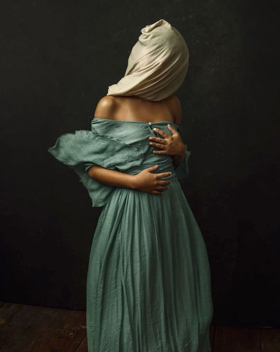 A hooded woman in a long strapless dress