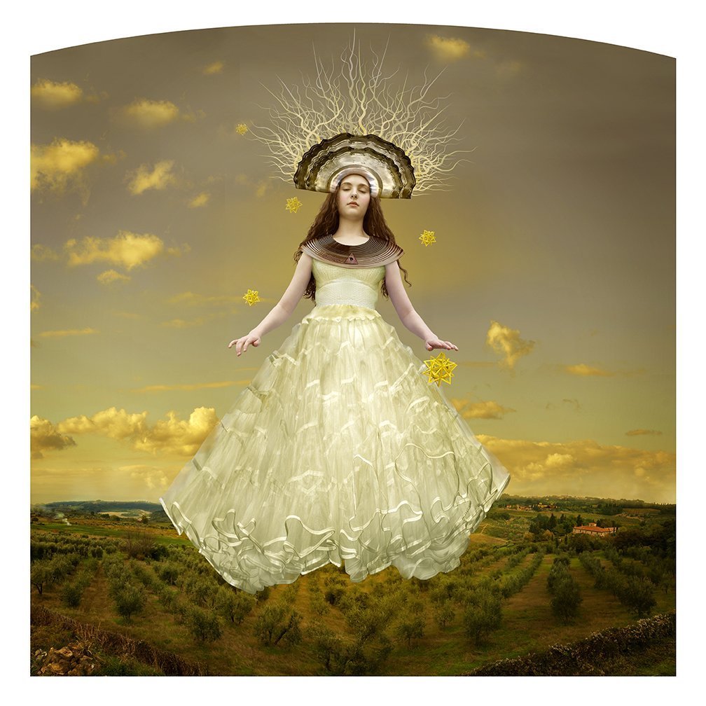 Portrait of a giant woman in religious garments standing on a golden country landscape with buildings