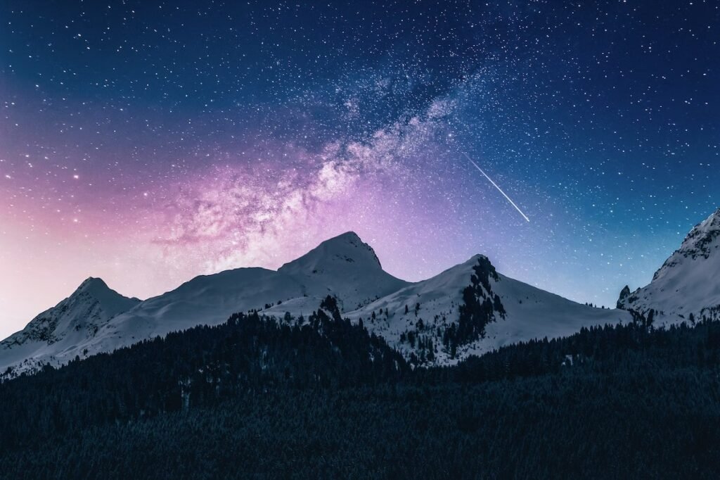 Snow-topped mountain range with stars above