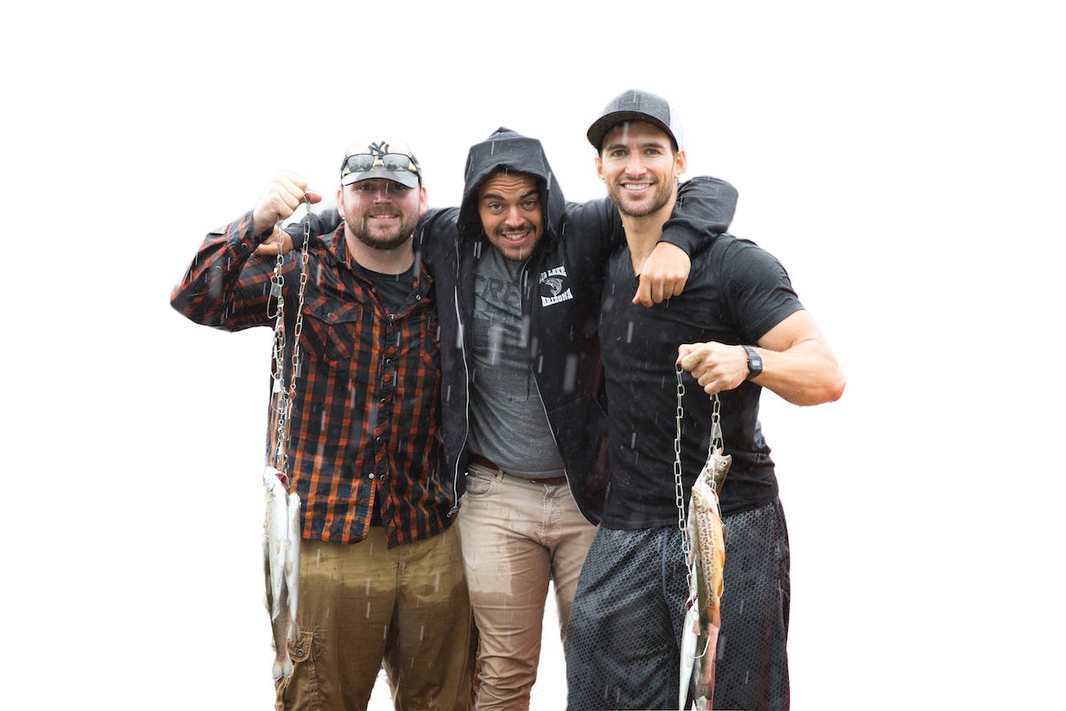 Three guys posing with fish caught with white background