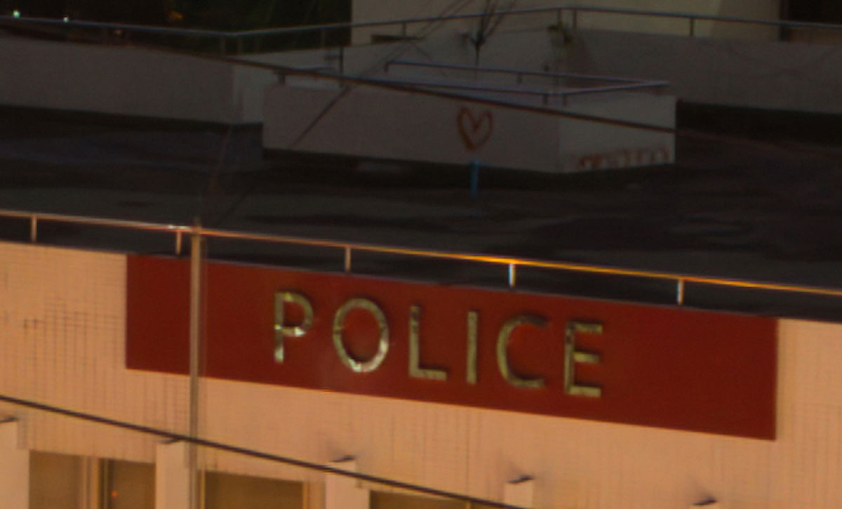 Luminar Neo Noise-reduced image of rooftop and police sign