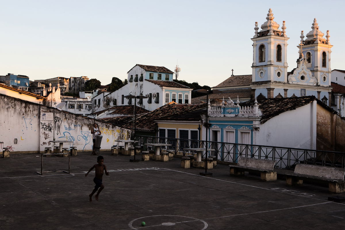 Shadow adjustment with Luminar Neo to an image of a boy playing in an urban court in front of a church