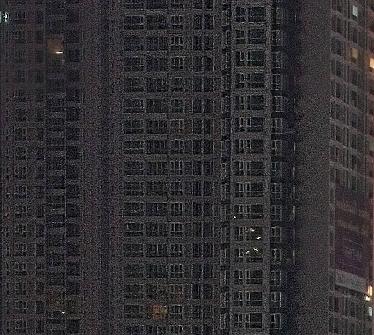 Close-up of sharpened photo of city building with pixelation and noise