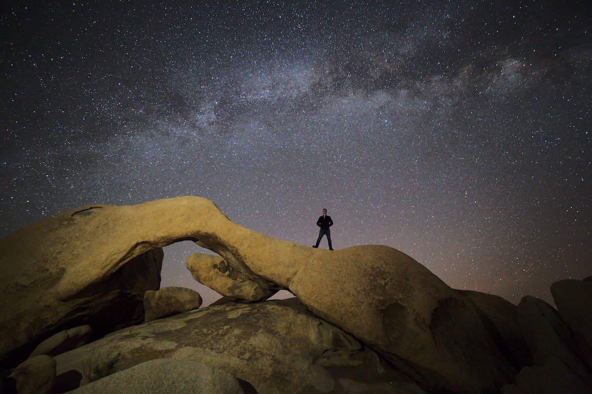 Nighttime image of a person standing on a desert formation under the stars edited with AfterShot Pro 3