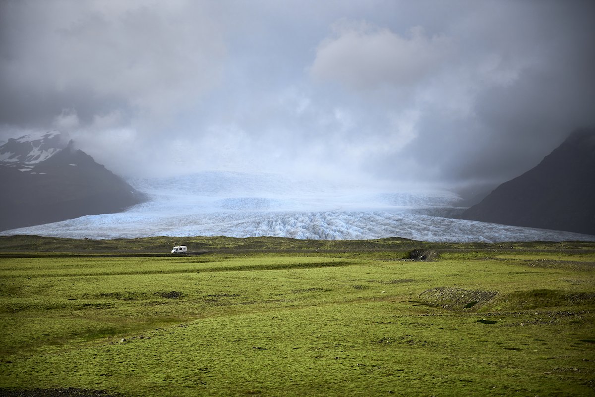 Image of a glacier with a field in the foreground with color adjustments from capture one