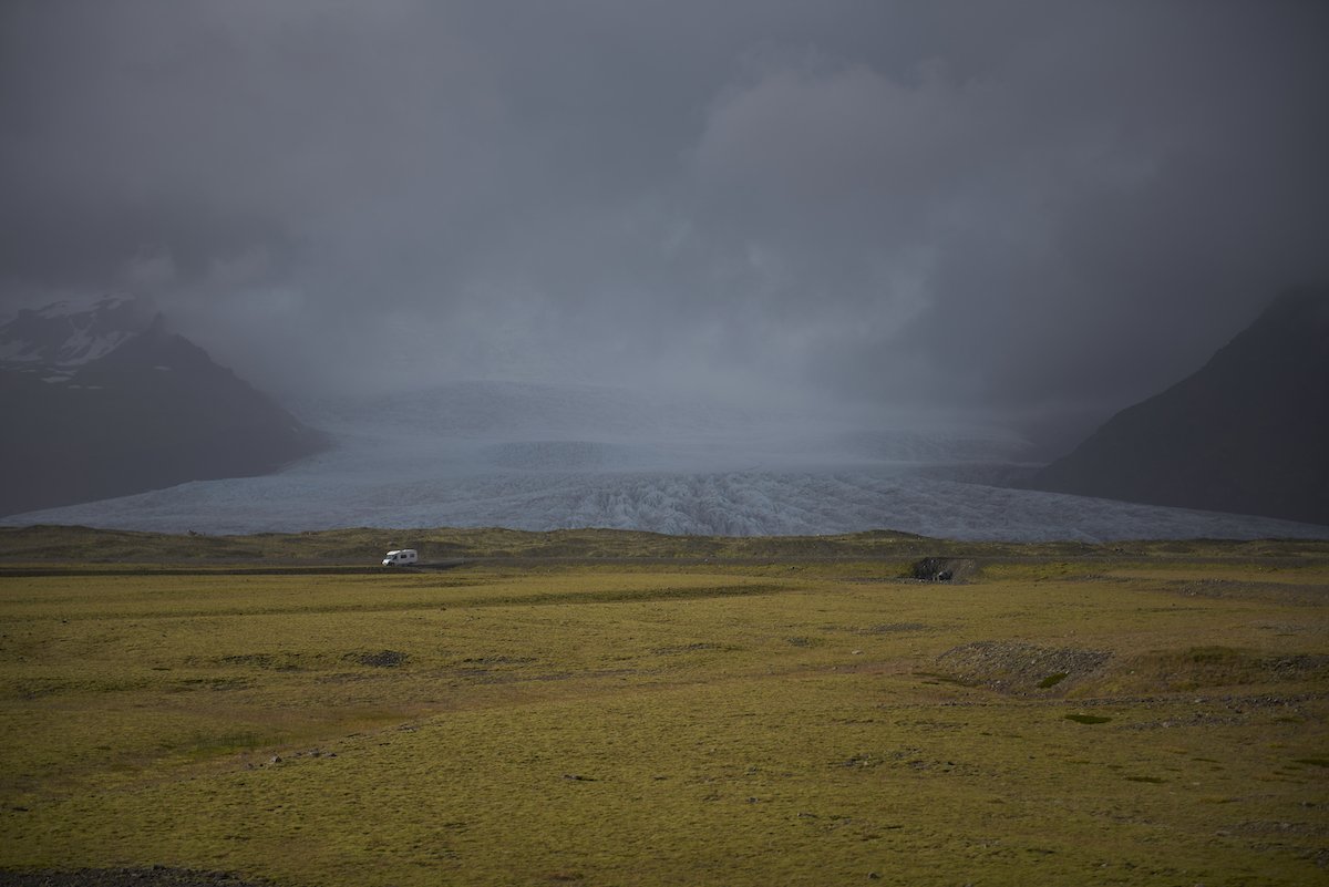 Image of a glacier with a field in the foreground