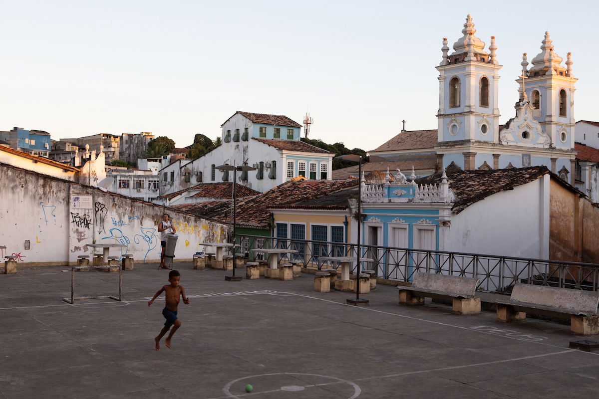 Lightroom RAW processed image of boy playing in an urban courtyard in front of a church