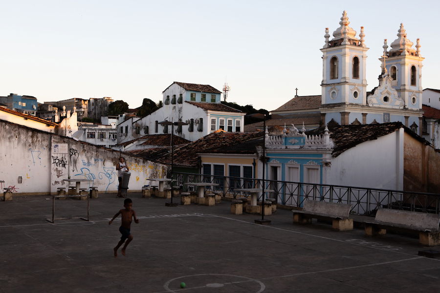 A boy playing in an urban courtyard in front of a church