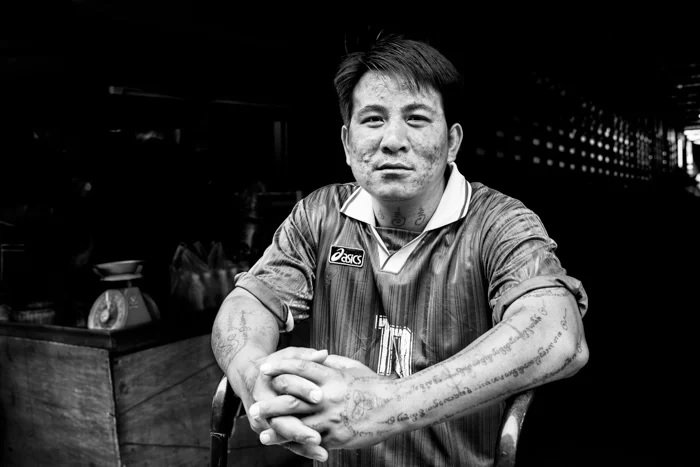 Black and white shot of Thai man sitting in chair