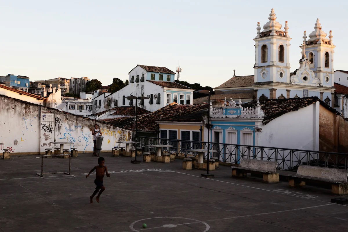 Capture One edited image of boy playing in an urban courtyard in front of a church