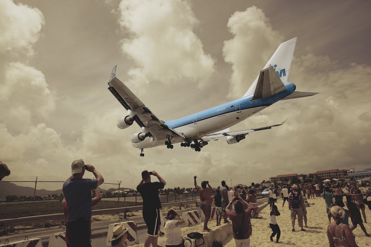 Image of a plane landing over a group of people with an ON1 preset applied