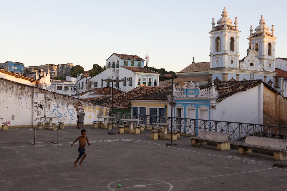 RAW file of a boy playing in an urban square in front of a church