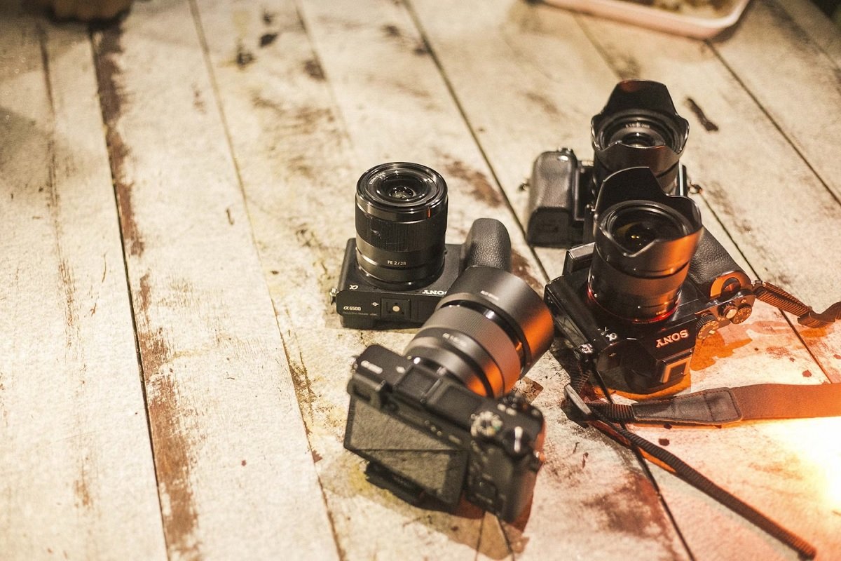Four Sony cameras on a wooden surface