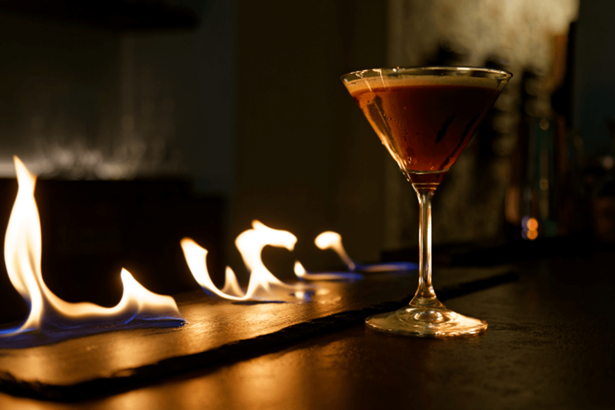 Stylish photo of a cocktail, with burning spirits in the background